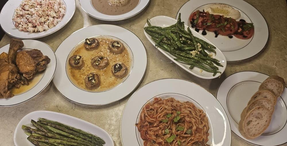 A spread of dishes, including pasta, vegetable, chicken, "scallops", and popcorn